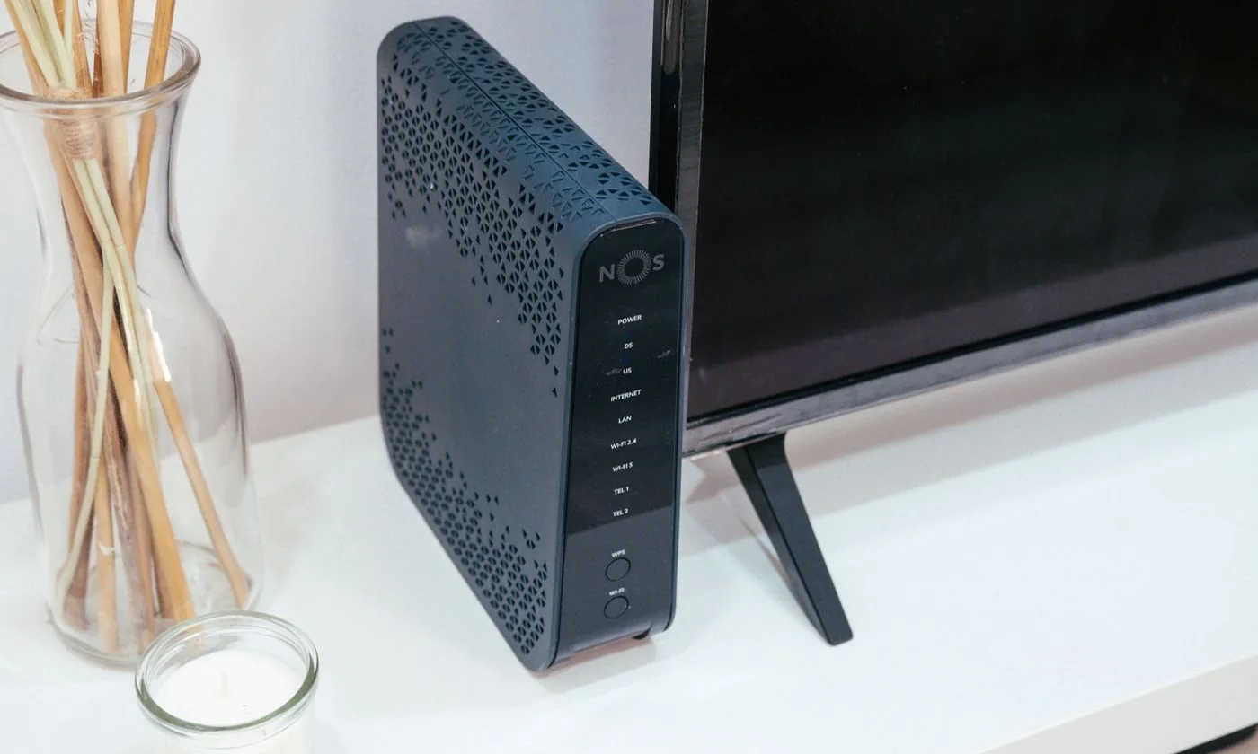 A home network router beside a television and decorative objects